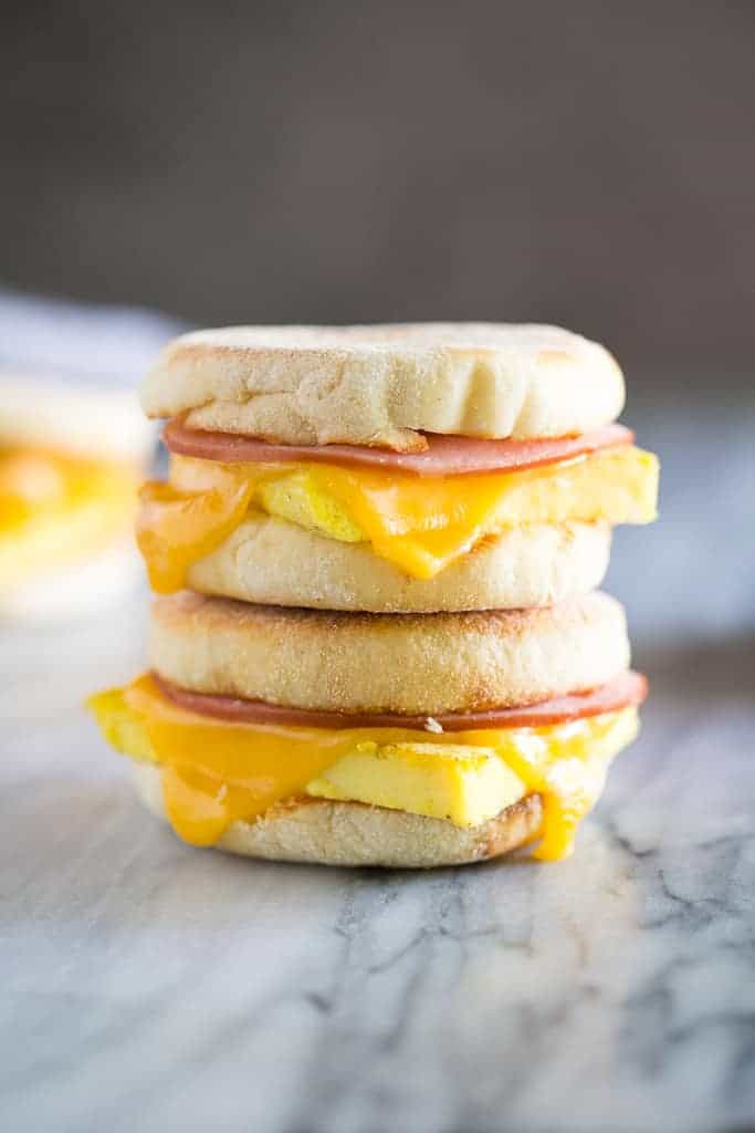 two small breakfast sandwiches stacked on top of each other on a marble countertop